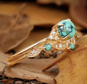 Detailed macro view of vintage gold ring set with oval turquoise and white crystals