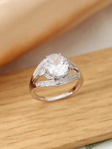 Dettaglio anello con zircone ovale, accenti di foglie e incastonatura pavé raffinata