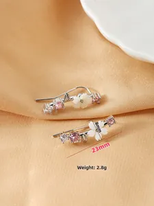Detail view of 23mm silver flower ear climbers with pink stones and 8mm center blossom