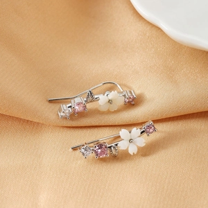 Elegant floral ear climbers with pink zircons and white flower petals on silk fabric