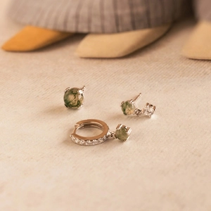 Detailed close-up of retro silver earrings set with natural green moss agate and zircons