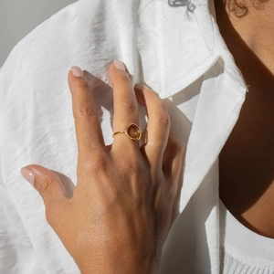 Close-up of minimalist gold hollow circle ring with pavé diamonds on a model's finger