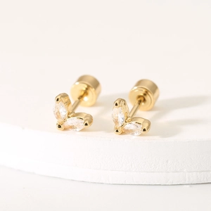 Detailed macro view of golden leaf-shaped stud earrings with marquise-cut zircon stones