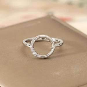 Macro detail of silver geometric ring featuring a hollow circle set with sparkling crystals