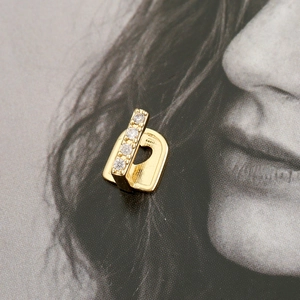 Macro-opname van een enkele gouden hiphop grillz met vier verticale diamanten op magazine