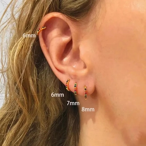 Detail showing rainbow zircon gold hoop earrings in 6mm, 7mm, and 8mm sizes worn on ear