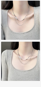 Gros plan d'un collier à double chaîne serpent argentée sur mannequin en tricot