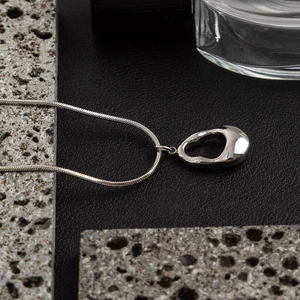 Minimalist silver water drop hollow pendant necklace on snake chain in modern industrial style
