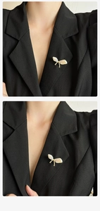 Dettaglio di un'elegante spilla a fiocco con perle su un bavero di un blazer nero