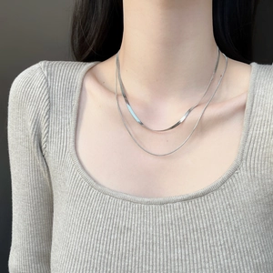 Collier double couche en maille serpent argenté sur le cou d'un mannequin pour l'élégance