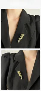 Detailed close-up of a golden dragon brooch with crystal inlay on a black suit lapel