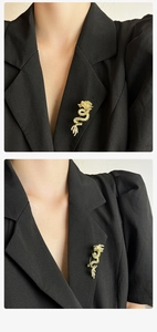 Detailed view of a golden dragon brooch with sparkling rhinestones on a black suit lapel