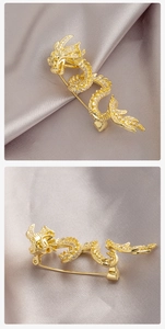 Detailed view of the golden dragon brooch back pin and sparkling crystal settings