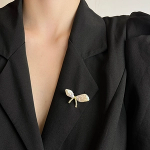 Spilla a farfalla elegante con perle irregolari e cristalli su un abito nero formale