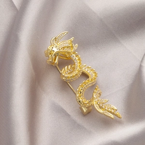 Exquisite gold dragon brooch with sparkling rhinestones on elegant grey silk background