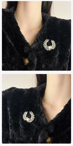 Detail van zirkoon korenar broche met parel op zwarte stof voor elegante look