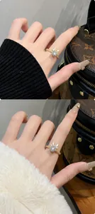 Detail van een draaiende gouden drakenring met zirkoniasteentjes aan een vrouwenhand