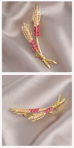 Nahaufnahme der goldenen Weizenähre-Brosche mit rosa Zirkonia im Farbverlauf