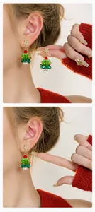 Detail van kerstboom oorhangers met groene kristallen en gouden ster op een model