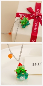 Detail van de meerkleurige kristallen kerstboomhanger aan een fijne zilveren ketting