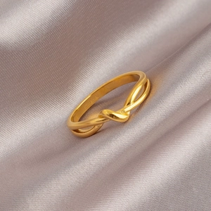 Elegant gold Mobius twist ring made of tarnish-free titanium steel on silk background