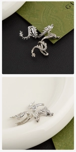 Macro detail of a silver dragon ear cuff featuring intricate scales and white zircon stones