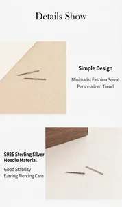 Detalle de pendientes minimalistas de plata de ley S925 sobre una superficie de cuero