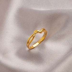 Elegant gold Mobius twist ring in titanium steel on soft silk background
