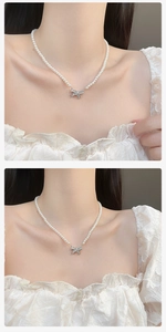 Detailed close-up showing white pearls and a crystal bow pendant on a choker necklace