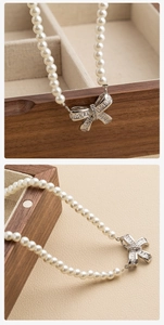 Detail of French vintage pearl necklace with silver bow pendant and clear zircon stones
