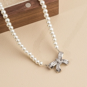 Elegant pearl necklace with silver crystal-studded bow pendant for women