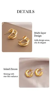 Detailed macro view of layered spiral gold earrings and chunky hoop set with clear zircons