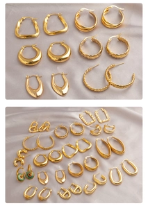 Detailed collection of chunky golden titanium steel hoop earrings on grey satin background