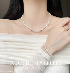 Exquisite pearl necklace and bracelet set with diamond-encrusted metal spacers on a model