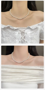 Detailed shot of a French vintage pearl necklace with sparkling spacers on a model