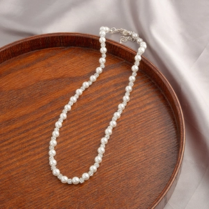 French vintage pearl necklace with rhinestone ball charm on silk background