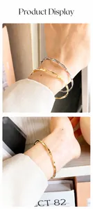 Detailed view of Mobius twist gold and silver titanium steel bangles on a wrist