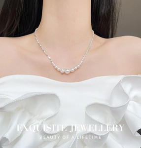 Gedetailleerde weergave van gegradueerde parels aan een zilveren ketting bij een model