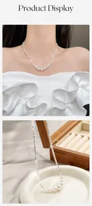 Detailoverzicht van zilveren ketting met vijf witte parels gedragen door een Aziatisch model