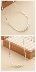 Detail van de ketting met zilveren kralen en witte parels in een mooi verloop