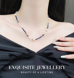 Detail of beaded necklace with blue lapis lazuli, white pearls and gold spacers on model