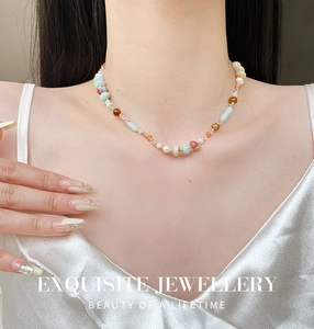 Detailed view of colorful natural stone and pearl beaded necklace worn on neck