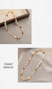 Macro detail of geometric glass bead necklace with gold links and colorful patterns