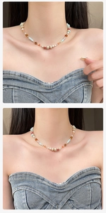 Detail of colorful stone and freshwater pearl beaded necklace worn on a model's neck