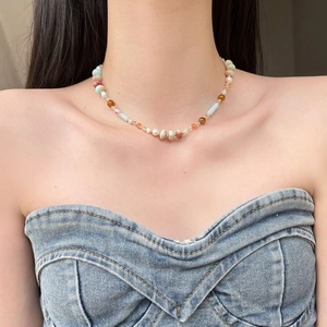 Beaded necklace with natural stones, freshwater pearls and colorful glass beads on a model