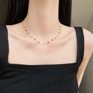 Minimalistische Goldkette mit bunten Natursteinperlen an einem Modell für den Alltag