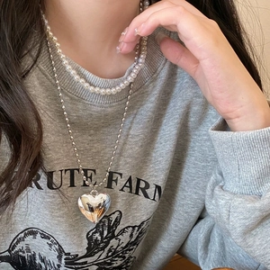 Collar de doble capa con perlas y acero de titanio con un colgante de corazón hueco