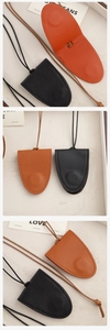 Detailed view of handmade textured leather pendant cases in black and brown with long lanyards