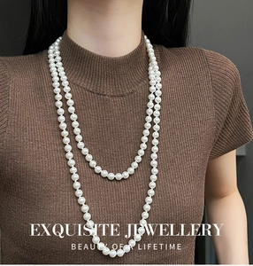 Close-up of double-layer vintage long pearl necklace on brown knit background