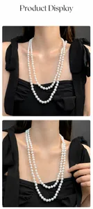 Detail of elegant double-layered cream pearl necklace worn by a model in black dress